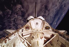 Picture shows the spacelab module mounted in the shuttle payload bay witht the earth in the background.