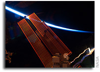 Photo: The Space Station's Solar Panels and a Crescent Earth 
